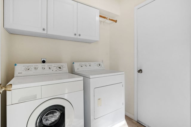 laundry area featuring separate washer and dryer and cabinet space