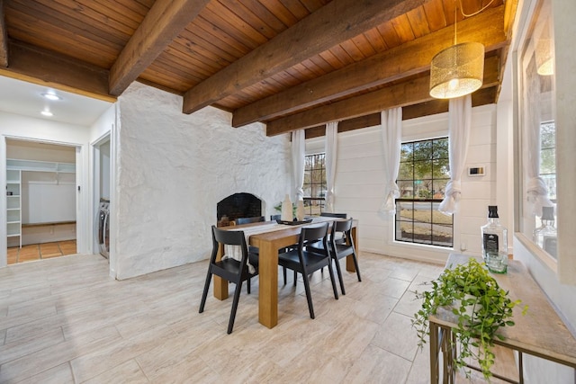 dining space featuring wooden ceiling, an outdoor stone fireplace, and beam ceiling