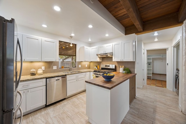 kitchen featuring stainless steel appliances, wooden counters, white cabinetry, a sink, and under cabinet range hood