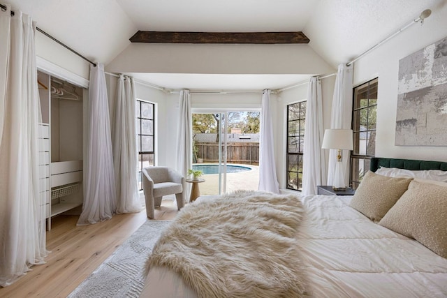 bedroom featuring vaulted ceiling, wood finished floors, and access to exterior