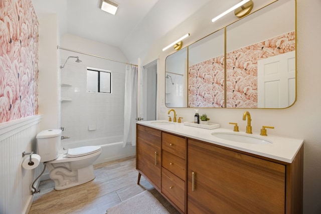 full bathroom featuring shower / bath combo with shower curtain, wainscoting, a sink, and toilet