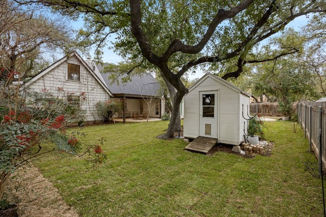 view of yard with a fenced backyard, an outdoor structure, a patio, and a storage unit