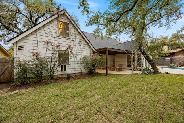 rear view of property with an outdoor pool, a patio area, a lawn, and fence