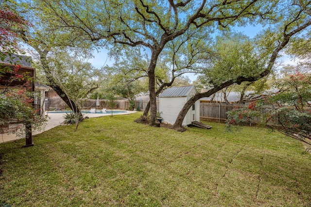 view of yard featuring a fenced backyard, an outdoor structure, a fenced in pool, and a shed