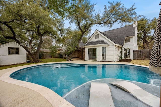 view of swimming pool with an outbuilding, a storage structure, a fenced backyard, and a fenced in pool