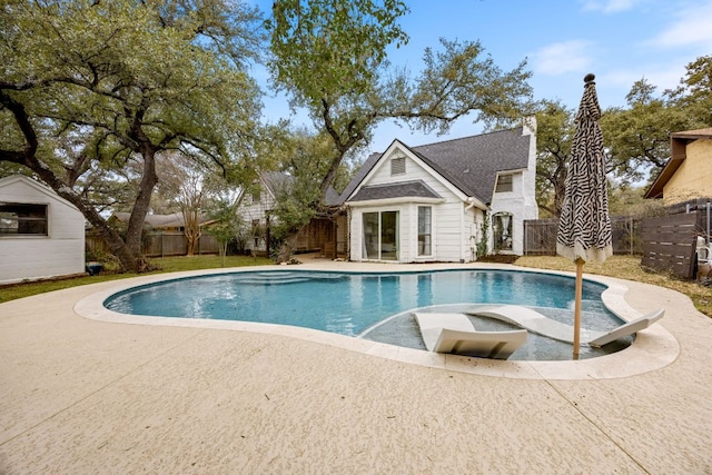 view of swimming pool with a patio, an outdoor structure, a fenced backyard, and a fenced in pool