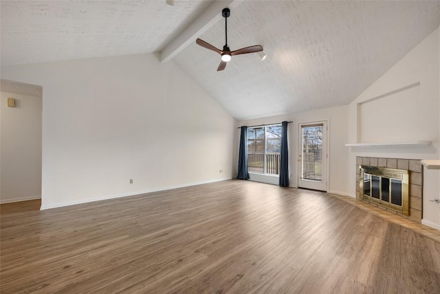 unfurnished living room with a fireplace, lofted ceiling with beams, a ceiling fan, a textured ceiling, and wood finished floors