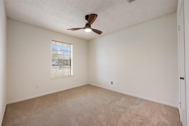 empty room with light carpet, ceiling fan, a textured ceiling, and baseboards