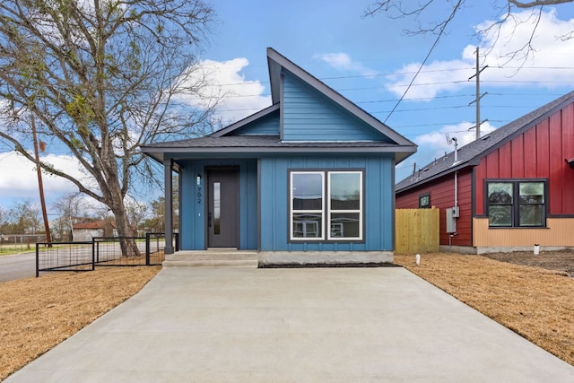 view of front of property featuring a shingled roof, board and batten siding, and fence