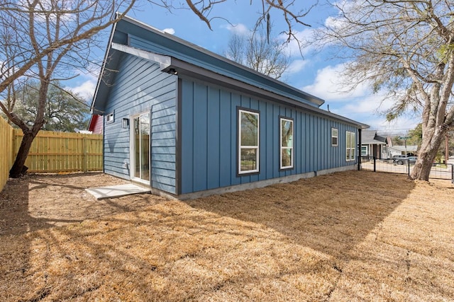 view of home's exterior with board and batten siding and a fenced backyard