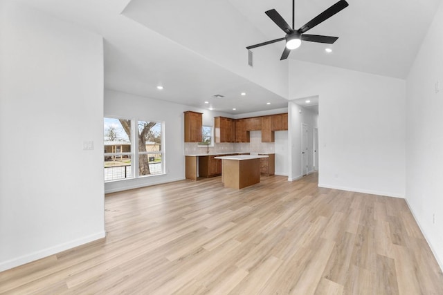 unfurnished living room with recessed lighting, ceiling fan, light wood-style flooring, and baseboards