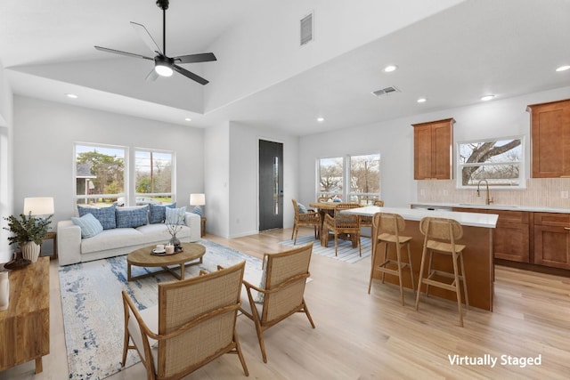 living area with light wood-type flooring, plenty of natural light, and visible vents