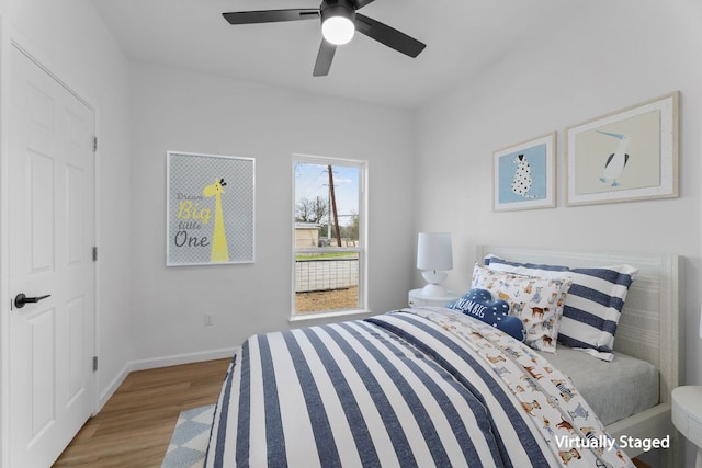 bedroom with ceiling fan, baseboards, and wood finished floors