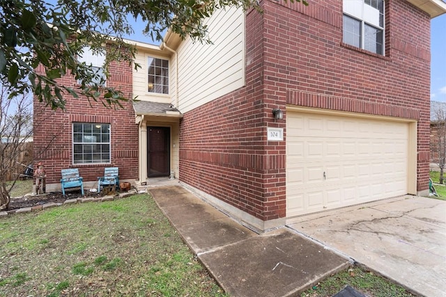 view of front of house featuring brick siding, driveway, and an attached garage