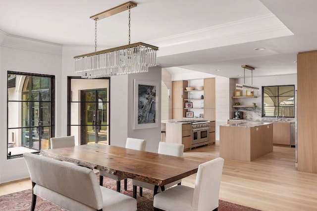 dining room with light wood-style flooring and ornamental molding