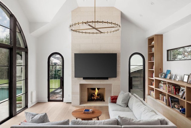 living room featuring lofted ceiling, a large fireplace, and wood finished floors