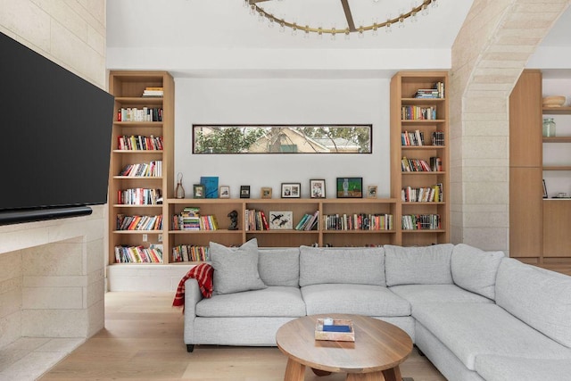 living area with built in shelves and wood finished floors