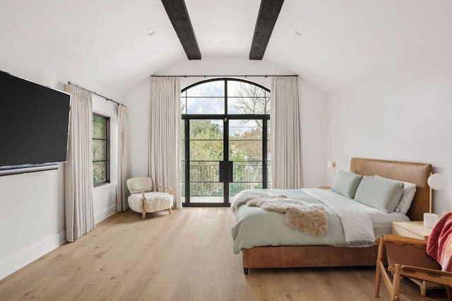 bedroom with lofted ceiling with beams, multiple windows, baseboards, and wood finished floors