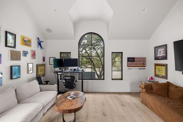 living room featuring light wood-style floors, baseboards, and vaulted ceiling