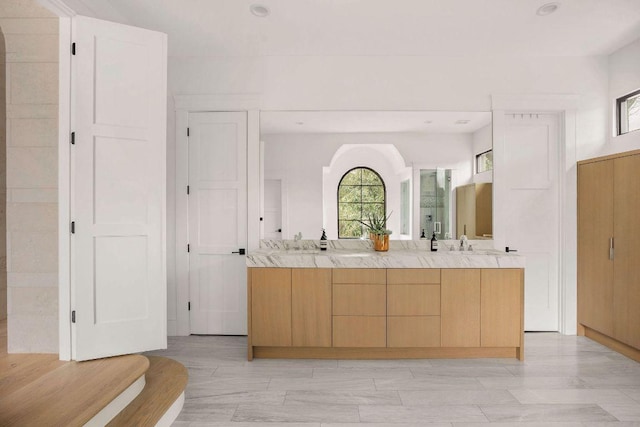 full bath featuring double vanity, a sink, and recessed lighting