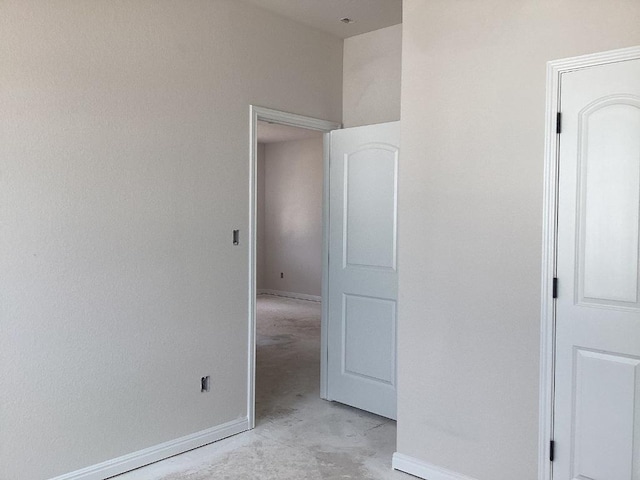 unfurnished bedroom featuring concrete floors and baseboards