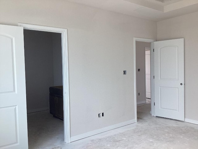 unfurnished bedroom featuring baseboards and unfinished concrete floors