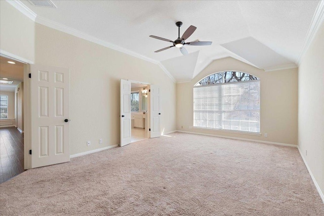 unfurnished bedroom featuring ornamental molding, carpet, vaulted ceiling, and baseboards