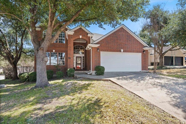 traditional-style home with brick siding, driveway, an attached garage, and fence