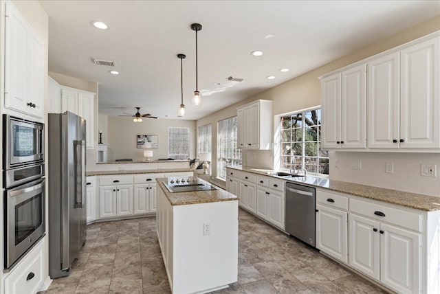 kitchen featuring appliances with stainless steel finishes, white cabinetry, and tasteful backsplash