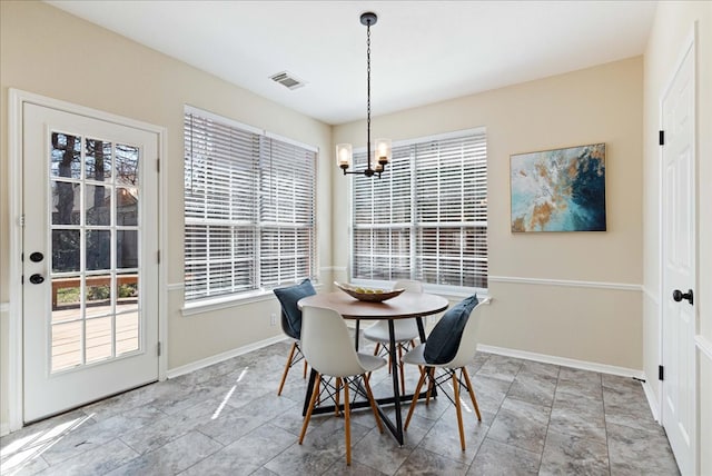 dining room featuring visible vents, a notable chandelier, and baseboards