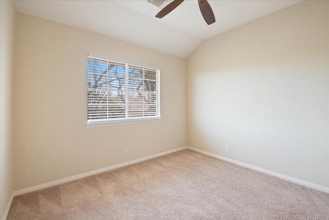 carpeted spare room featuring lofted ceiling, ceiling fan, and baseboards