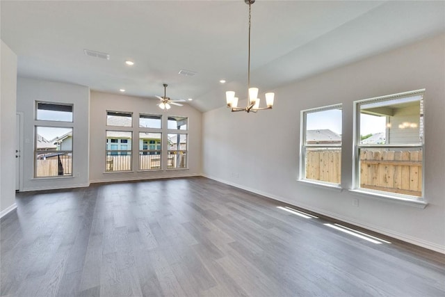 186 Du Bois Ln, Kyle, TX 78640 - spare room featuring vaulted ceiling, visible vents, baseboards, dark wood-style flooring, and ceiling fan with notable chandelier