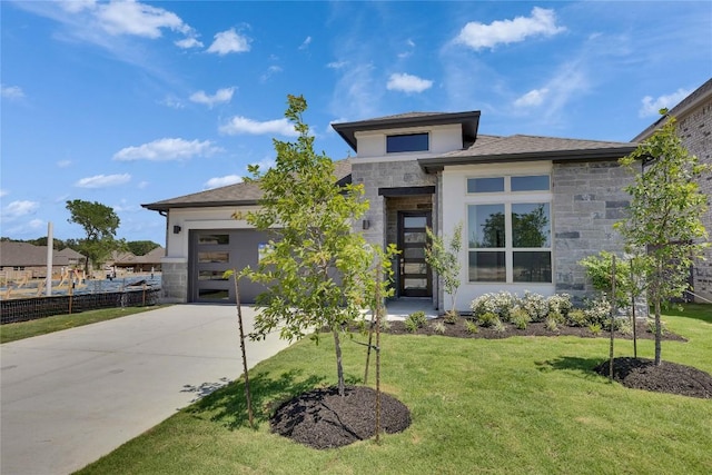 186 Du Bois Ln, Kyle, TX 78640 - prairie-style house with concrete driveway, stone siding, a front yard, and stucco siding