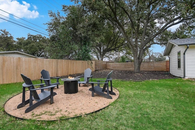 view of yard with a fenced backyard and a fire pit