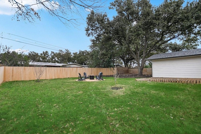 view of yard with a fenced backyard and a fire pit