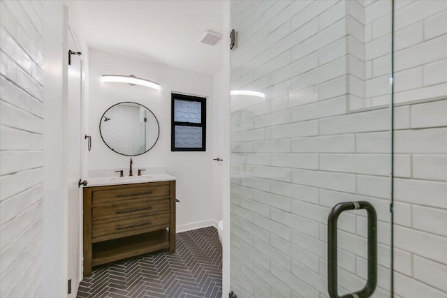 bathroom featuring visible vents, baseboards, brick floor, a tile shower, and vanity