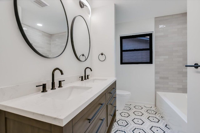 bathroom with visible vents, a sink, toilet, and double vanity