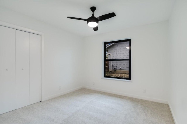 unfurnished bedroom featuring carpet floors, a closet, a ceiling fan, and baseboards