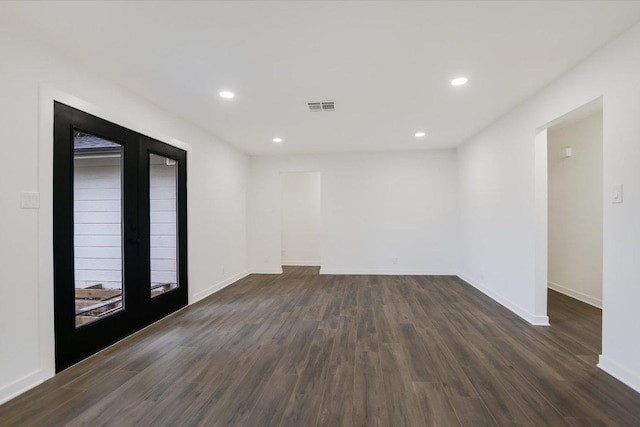 empty room featuring visible vents, baseboards, dark wood-style floors, french doors, and recessed lighting