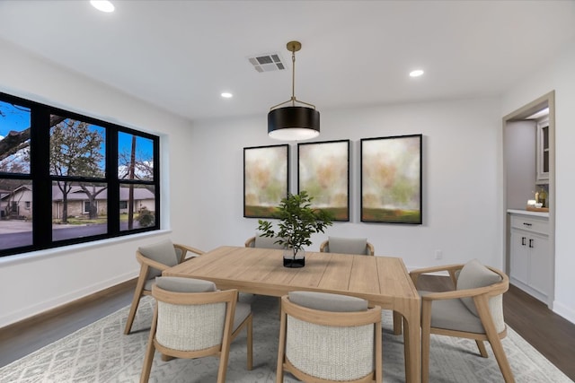 dining room featuring baseboards, wood finished floors, visible vents, and recessed lighting