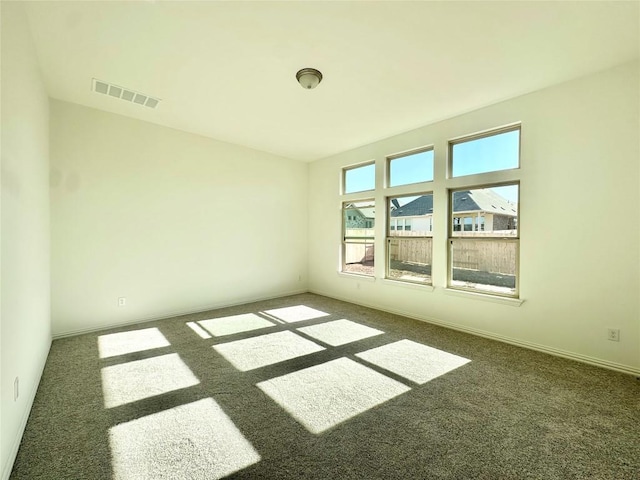 carpeted empty room with visible vents and baseboards