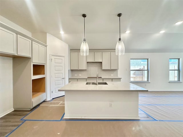 kitchen with a sink, decorative backsplash, an island with sink, and recessed lighting