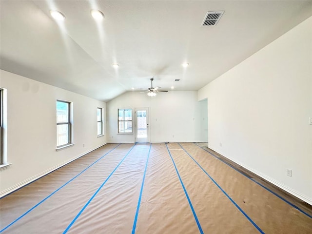 unfurnished room with vaulted ceiling, a ceiling fan, visible vents, and baseboards