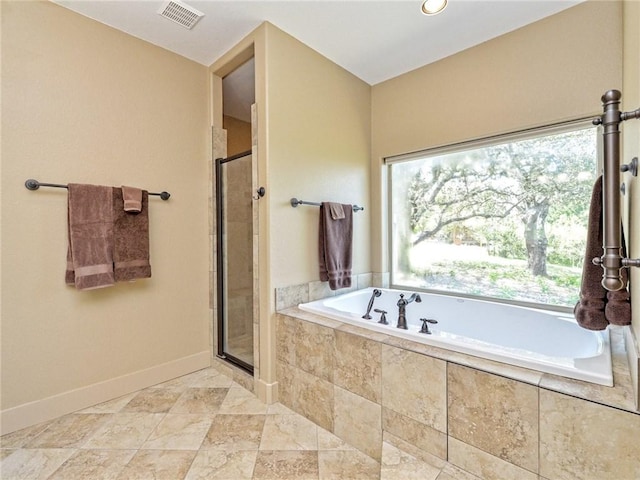 full bathroom featuring a garden tub, a shower stall, visible vents, and baseboards