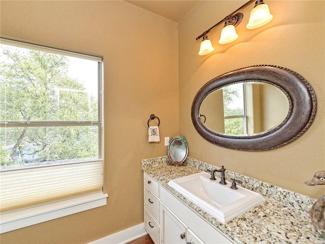 bathroom with vanity, a wealth of natural light, and baseboards