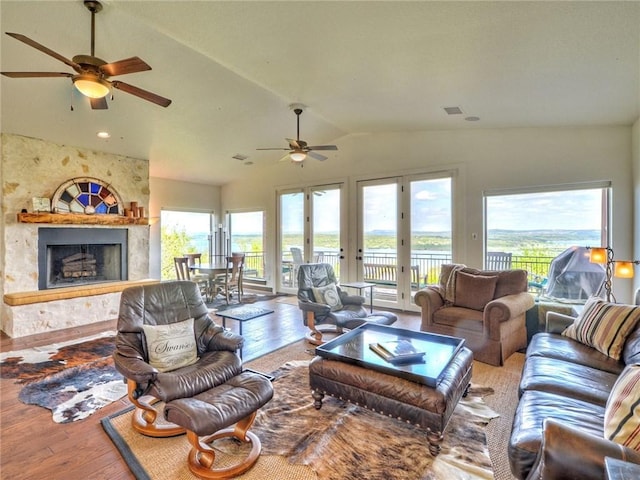115 Hill Loop, Spicewood, TX 78669 - living room featuring a fireplace, wood-type flooring, a ceiling fan, lofted ceiling, and visible vents