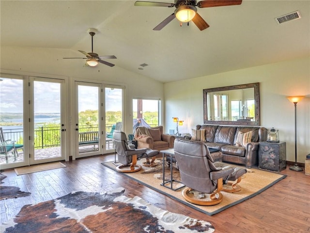 living room with ceiling fan, visible vents, vaulted ceiling, and wood finished floors