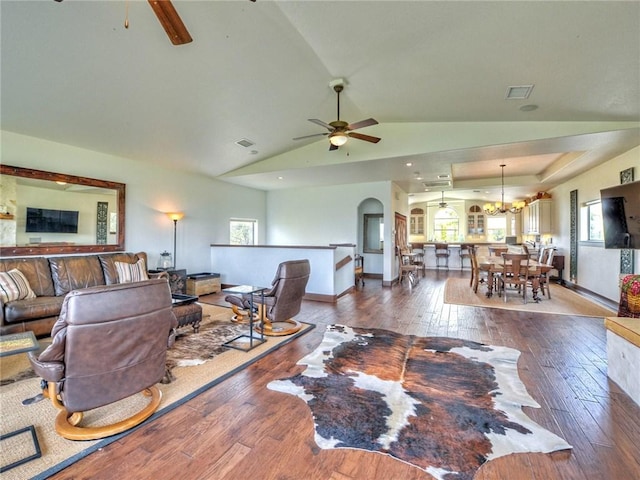 living room with visible vents, ceiling fan with notable chandelier, arched walkways, and hardwood / wood-style flooring