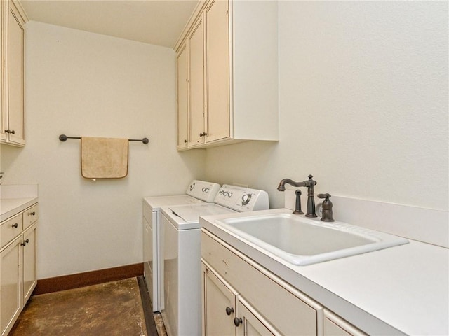 washroom featuring cabinet space, baseboards, a sink, and independent washer and dryer