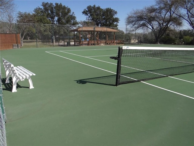 view of tennis court featuring fence